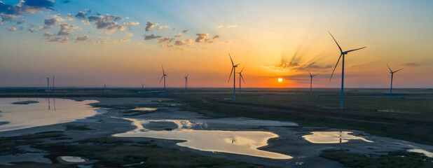 Wind turbine at beautiful orange red sunset © slava2271