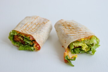 Tortilla with fried chicken meat and vegetables isolated on white background