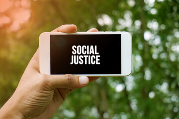 SOCIAL JUSTICE word on smartphone with bokeh in background