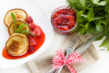 Pancakes with fresh strawberry sauce.Healthy breakfast, white wooden board
