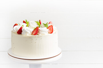 Beautiful white cake decoraited with meringue and fresh strawberries. White background