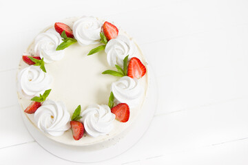 Beautiful white cake decoraited with meringue and fresh strawberries. White background