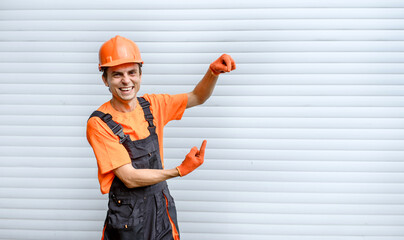 Young happy laughing man builder construction worker with hands in different position looking at the camera on white background
