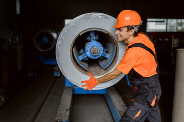 Close up of a happy worker engineer pushing a metal coil and preparing it for profiling the metal tile roof process.