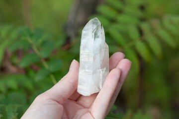 White quartz rock crystal in female hand close up.
