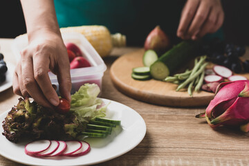 Woman preparing fruit and vegetables for making vegan salad