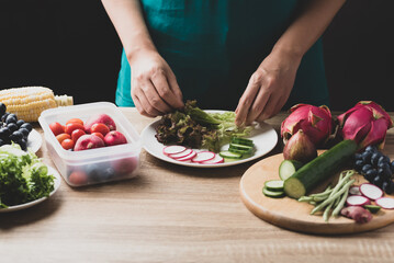 Woman preparing fruit and vegetables for making vegan salad