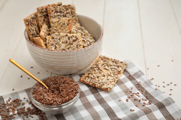 Bowl with cereal cookies and flax seeds on table