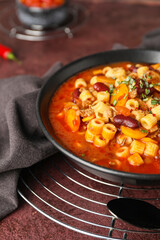Bowl with tasty pasta and beans on table