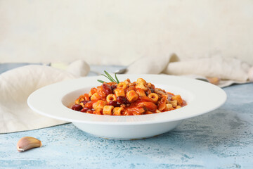 Bowl with tasty pasta and beans on table