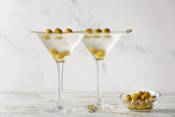 Glasses of tasty martini cocktail with olives on white background