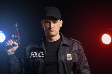 Obraz premium Aggressive police officer with gun on dark background