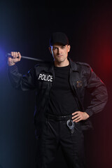 Fototapeta na wymiar Aggressive police officer on dark background