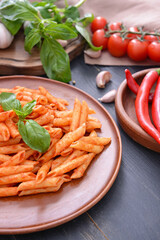 Plate with tasty pasta and tomato sauce on table