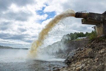 Spillway into the river from an industrial complex. Photo on the topic of ecology.