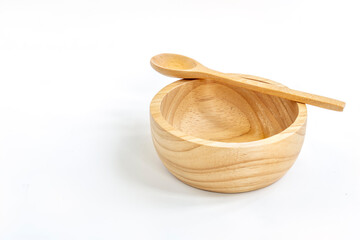 Isolated empty small wooden bowl and spoon on white background. Spoon is put on the edge of bowl. Natural line pattern in wooden bowl, clipping path in file.