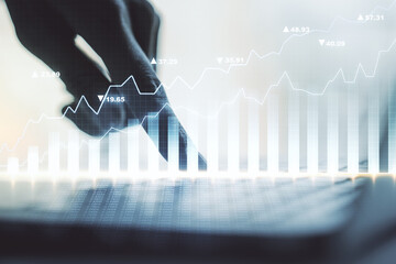 Abstract creative financial graph with hand typing on laptop on background, financial and trading...