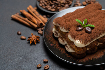 Classic tiramisu dessert on ceramic plate on concrete background