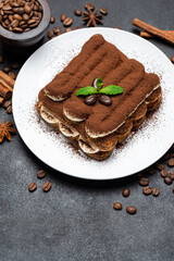 Classic tiramisu dessert on ceramic plate on concrete background