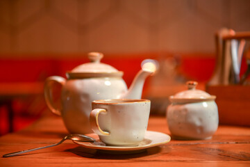 White tea set served on a rustic wooden table in a restaurant. Tea time. Ceramic tea set. Eating out concept.
