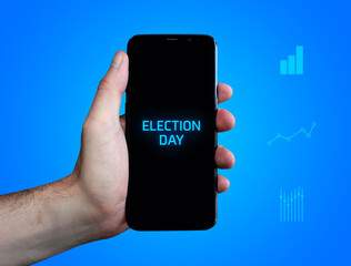 Election Day. Hand holds phone (cell phone). Word on display. Charts on blue background. Business
