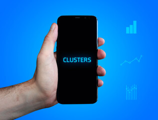 Clusters. Hand holds phone (cell phone). Word on display. Charts on blue background. Business