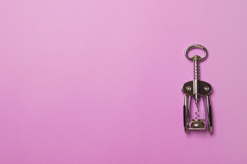 metal corkscrew on purple colored paper background with copy space