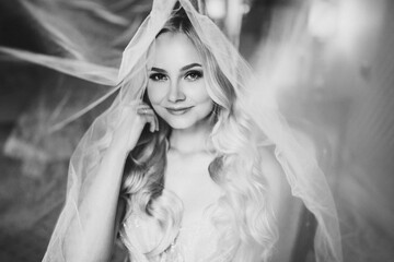 Monochrome portrait of sensuality and charming smiling young blondie. Beautiful sexy lady with long hair, and perfect make up dreaming with closed eyes. Concept of beauty. Morning of bride.
