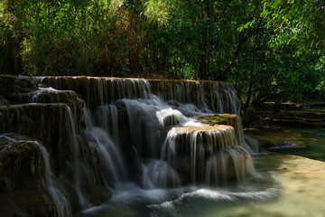 Fototapeta na wymiar Une cascade vue de côté aux chutes de Kuang Si, à Luang Prabang, au Laos.