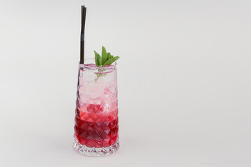 Red colorful refreshing cocktail with ice and lime. Fruit tropical mix drink.