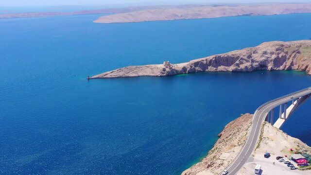 Traffic on Krk Bridge driving between Krk Island and mainland Croatia. Aerial view.