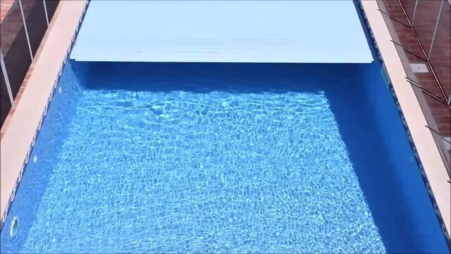 Electric pool cover closing on a home swimming pool