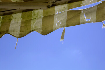 old and damaged and dirty striped awning