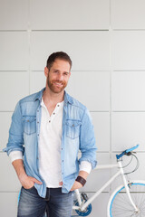 Pensive guy with denim shirt next to his bike