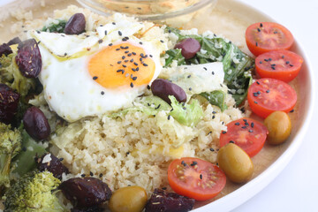 combinate dish with olives tomatoes broccoli and fried egg