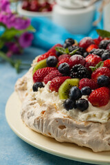 Meringue Pavlova cake with fresh fruit. Front view.