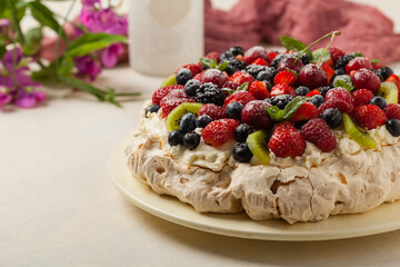 Meringue Pavlova cake with fresh fruit. Front view.