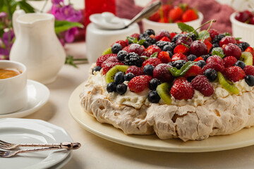 Meringue Pavlova cake with fresh fruit. Front view.