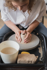 Fototapeta na wymiar Hands of a potter, creating an earthen jar on the circle