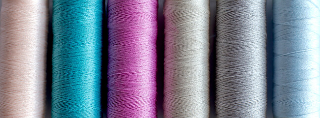 Colored thread in spools on white backgrond