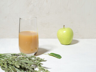 A glass with juice stands on a light background. Horizontal background, copy space.