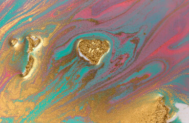 Piles of gold sequins on pink and blue smudges of paint. Abstract pattern.