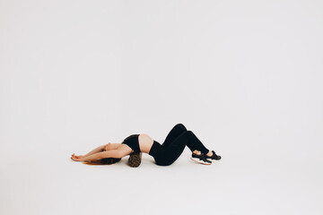 Fototapeta na wymiar Fitness woman doing stretching workout. Full length shot of a young woman on a white background. Stretching and Motivation
