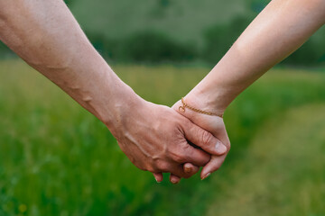 A young couple, a man and a woman holding hands, the photo symbolizes friendship and support