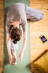 Selbstklebende Fototapeten top view of woman doing yoga at home © Melinda Nagy