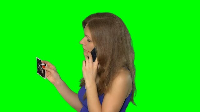 woman talk on phone in hand hold picture of pregnancy. Chroma key screen. 4K