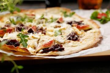 A flatbread with goat cheese, figs and red onion jam. Tasty pizza on crunchy dough.