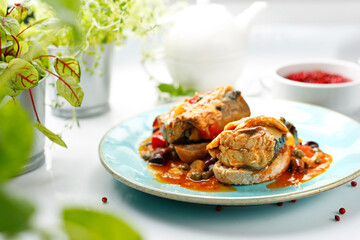 Mackerel baked in tomato sauce with capers. Suggestion of serving a dish on a plate. food background
