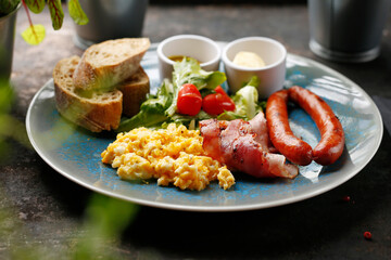 Nutritious continental breakfast, scrambled eggs, fried sausage and vegetable salad. Ready dish served in a hot pan. Suggestion of serving a dish on a plate. food background