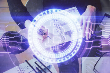 Cryptocurrency hologram over woman's hands writing background. Concept of blockchain. Double...